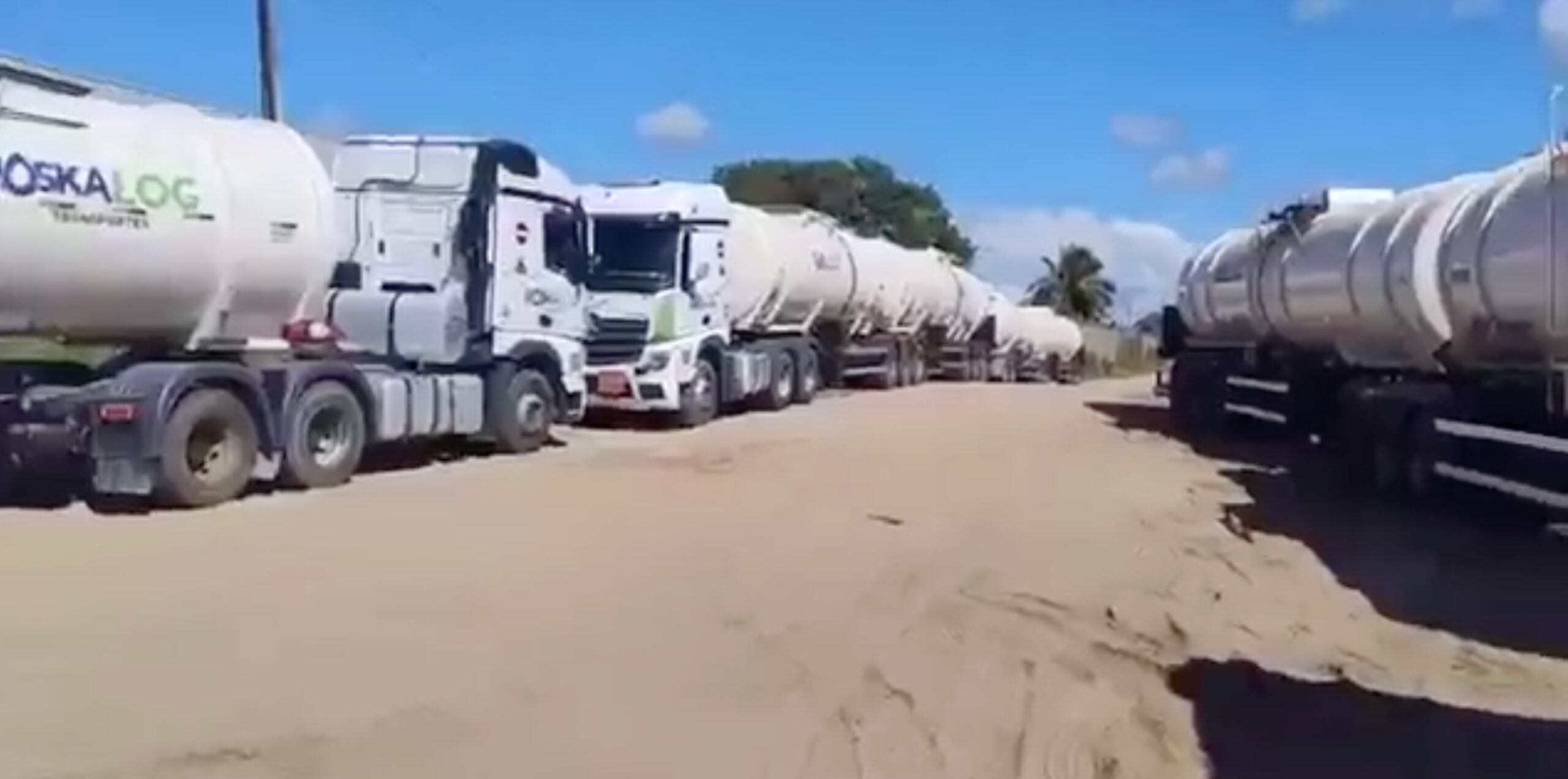 Carretas-tanque carregadas de combustível abandonadas em estrada de terra na Bahia após operação policial contra o PCC.