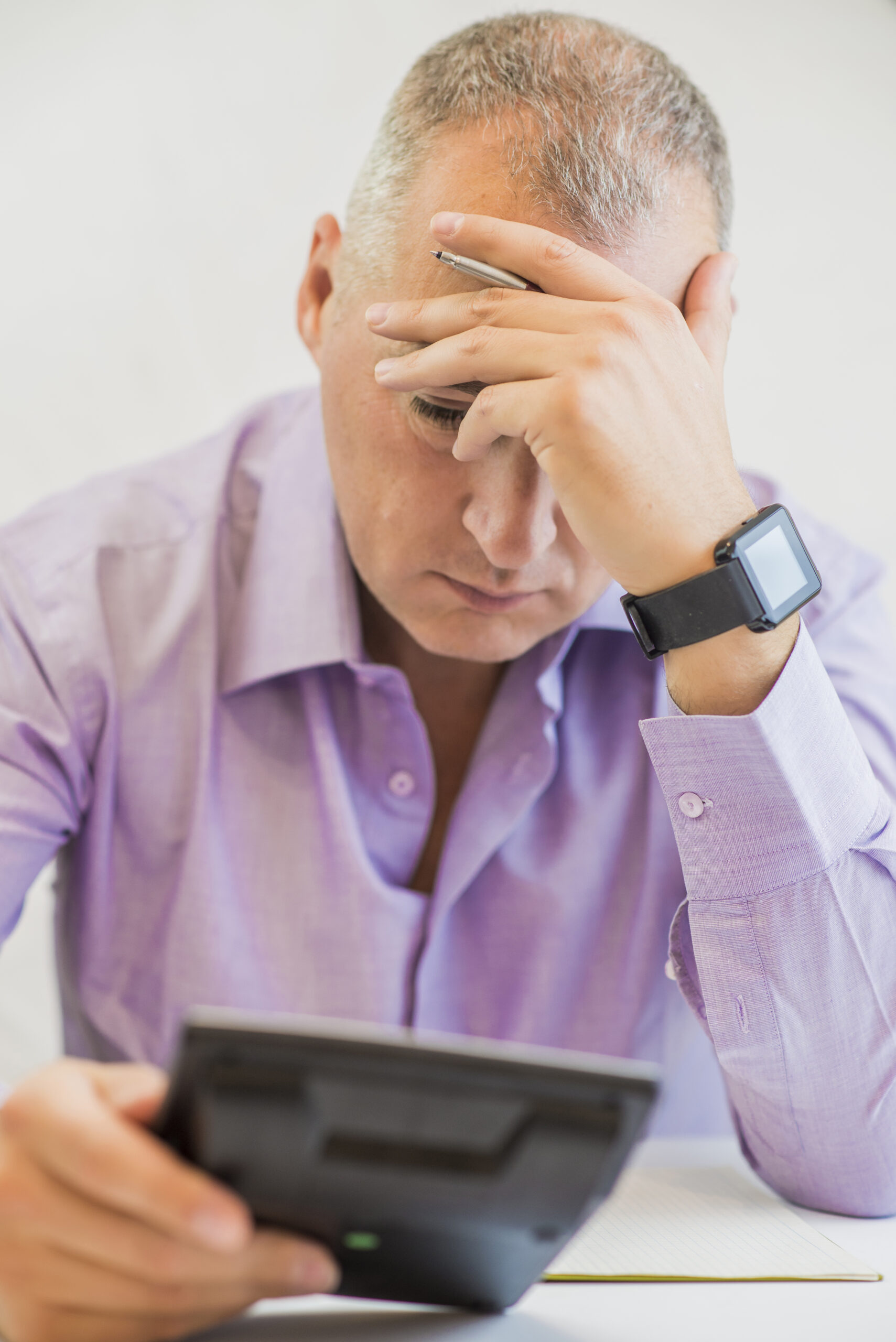 Empresário calculando com expressão de preocupação