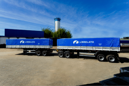 Carreta graneleira da Librelato com lona azul, estacionada no pátio industrial, simbolizando a expansão da produção em Guarulhos.