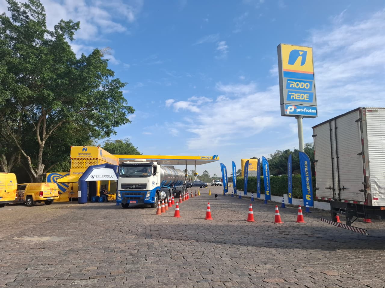 Carreta da Saúde instalada em posto de combustível, com caminhões e estrutura de atendimento para caminhoneiros.