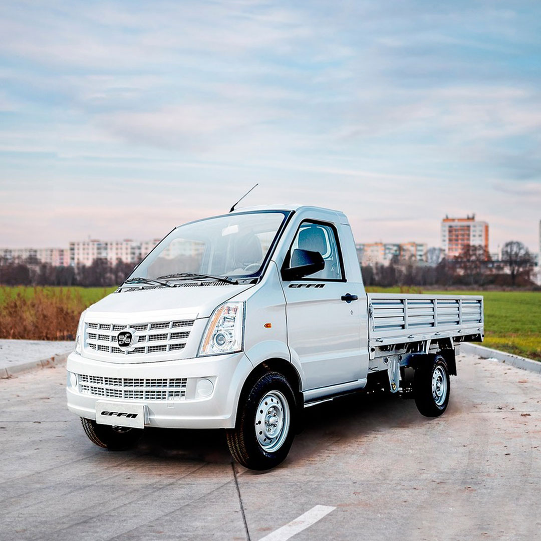 Utilitário leve da marca Effa estacionado em via urbana com fundo de cidade