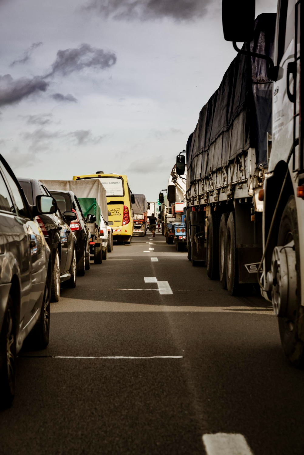 Rodovia com trânsito intenso de caminhões, carros e ônibus, reforçando a importância da direção consciente e segura.