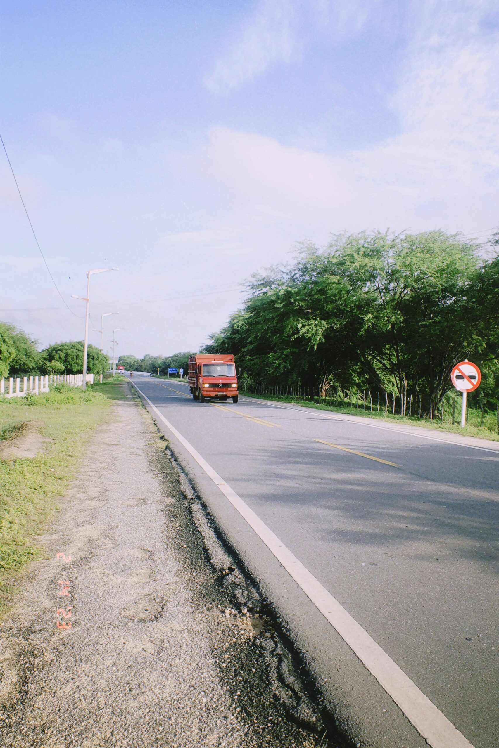 Caminhão vermelho trafegando em estrada brasileira, simbolizando o papel histórico dos caminhoneiros no crescimento do país.