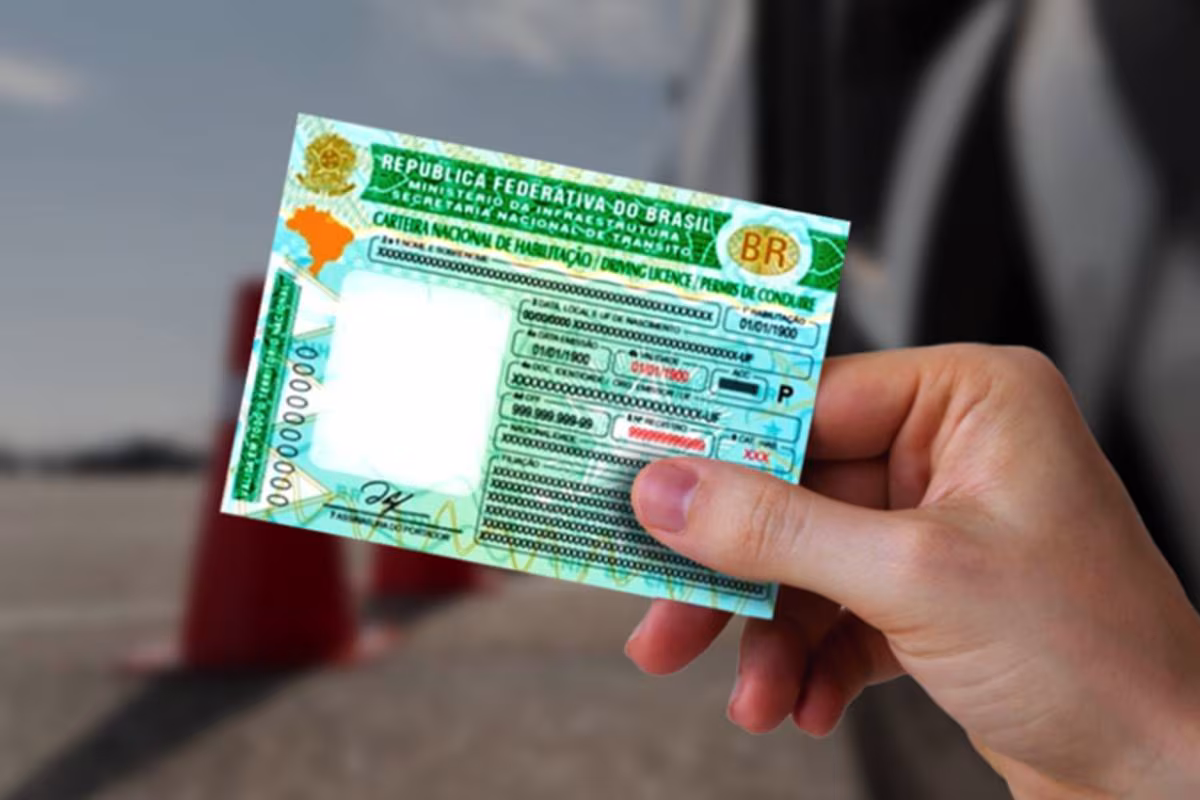 Mão segura um documento veicular digital em formato de cartão, com QR Code, exibido na tela de um celular.