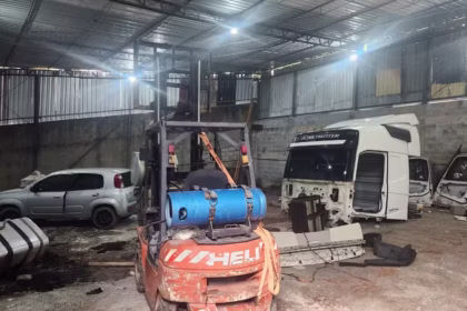 Galpão com várias equipamentos e veículos desmontados.