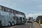 Ônibus parado no acostamento de uma rodovia, com trânsito ao lado e veículos à frente.