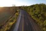 Vista aérea de rodovia asfaltada cercada por vegetação verde.